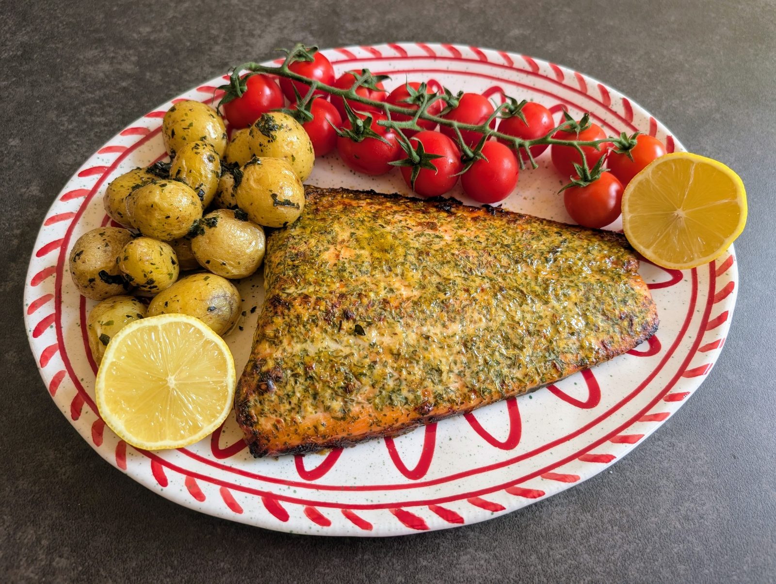 Herb-crusted salmon with new potatoes, vine tomatoes and lemon